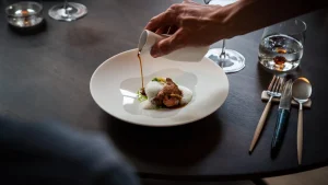 Een gerecht wordt aan tafel afgemaakt bij Restaurant Luwte