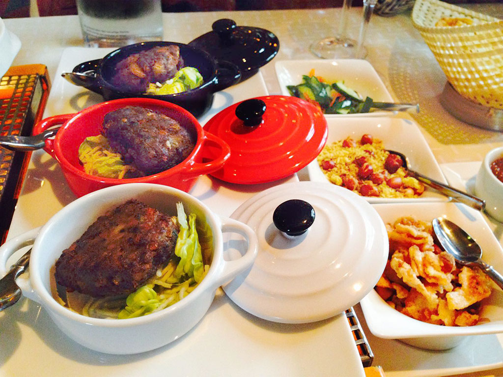 Indonesische rijsttafel met meerdere kleine pannen en schalen — Restaurant Spandershoeve
