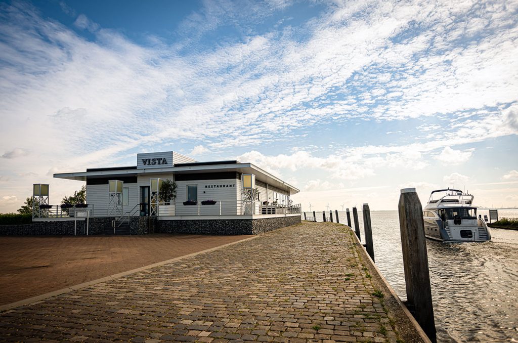 Restaurant VISTA aan de haven met duidelijk gevelopschrift en boten op de achtergrond — VISTA Willemstad