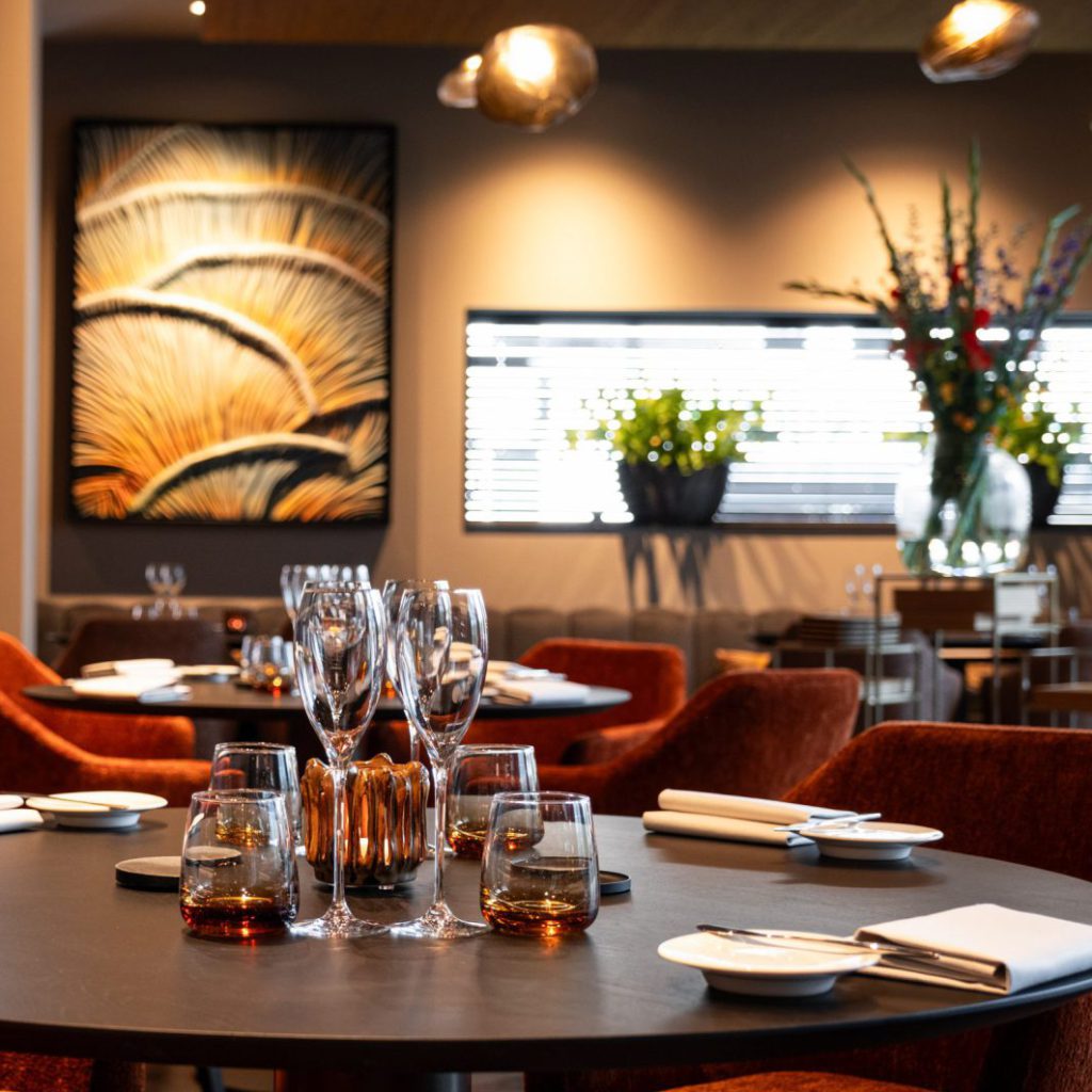 Gedekte tafels met wijnglazen en roodbruine stoelen — Restaurant Joann
