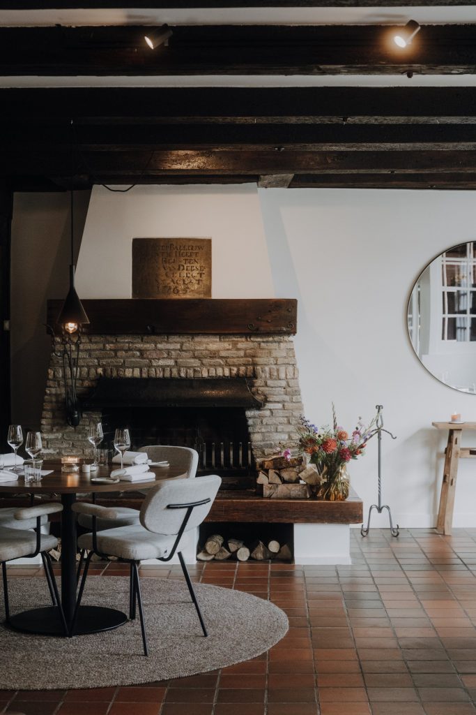Eetzaal met historische haard en gedekte tafels; staande foto — Rozewied