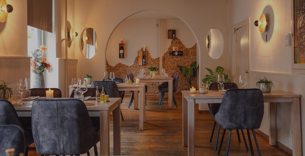 Lichte eetzaal met houten tafels en bloemen — De Lindeboom New Style