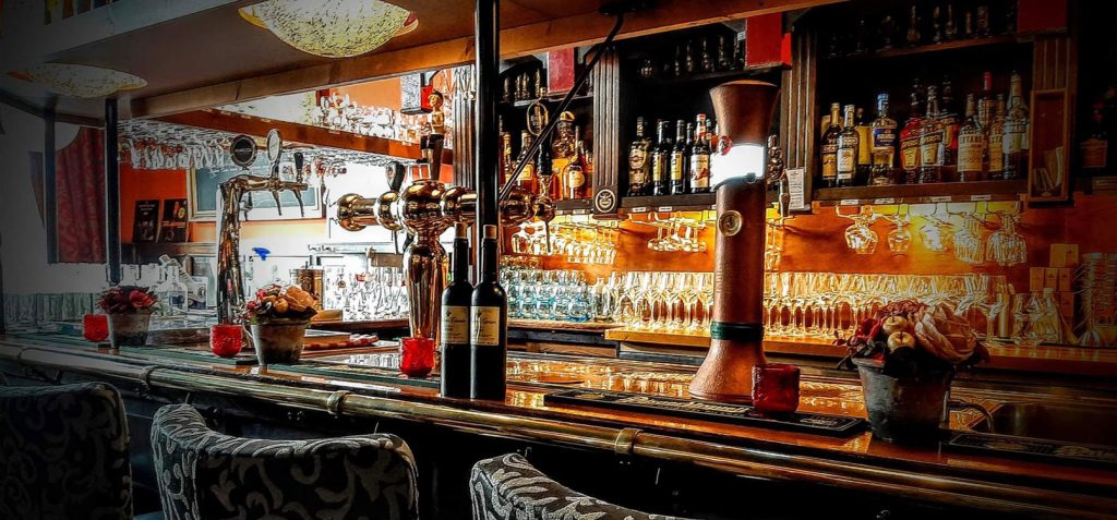 Bar met glazen, flessen en rijk gedecoreerde inrichting — Eterij & Tapperij ’t Raedthuys
