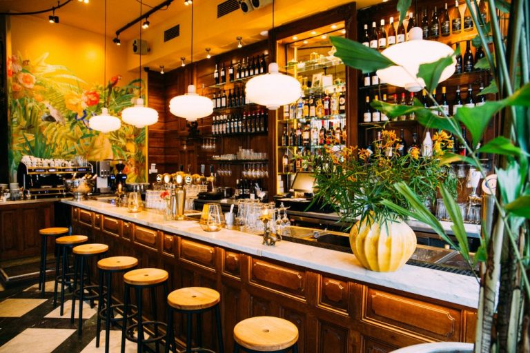 Kleurrijk barinterieur met planten en barkrukken — Café Samabe