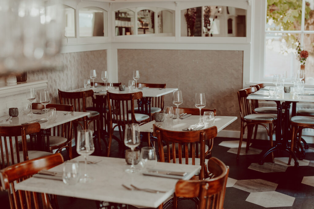 Bistrozaal met houten stoelen en licht gedekte tafels; afkomstig van de specifieke bistropagina — Bistro De Gieser Wildeman