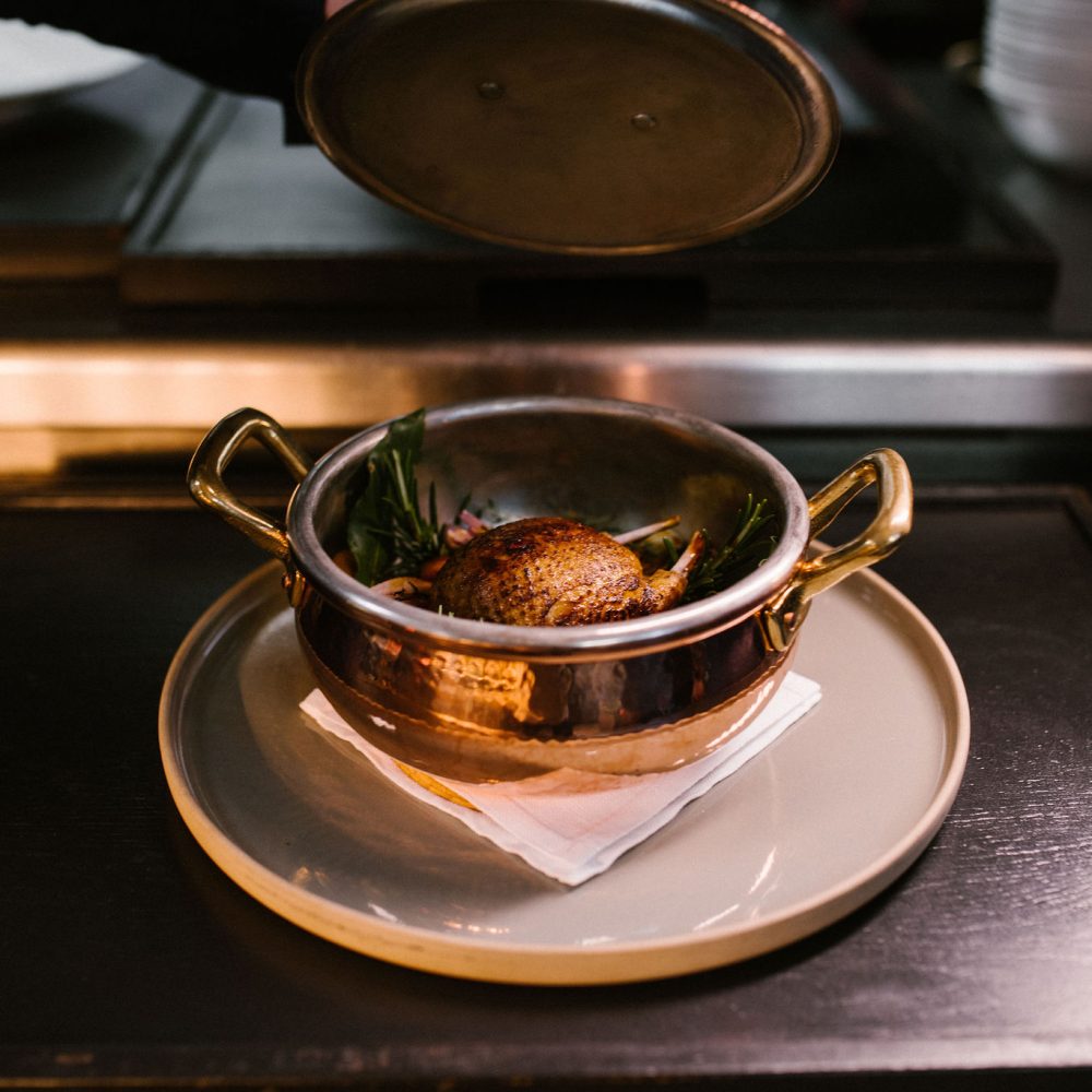 Gerecht in een koperen pannetje op een bord — Restaurant Tribeca