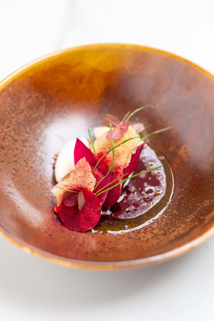 Gerecht op een bruin bord met kleurrijke garnering — Restaurant Zenith