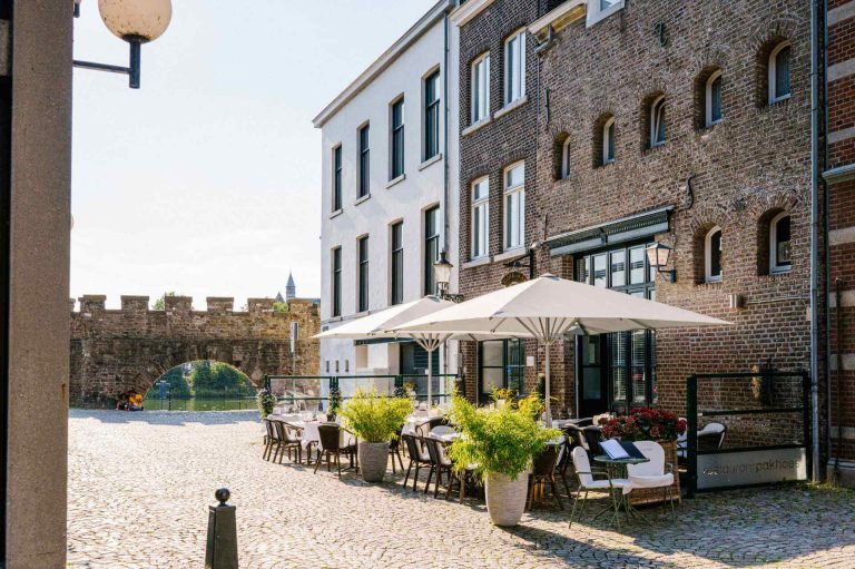 Gevel van het restaurant met terras aan de kade.