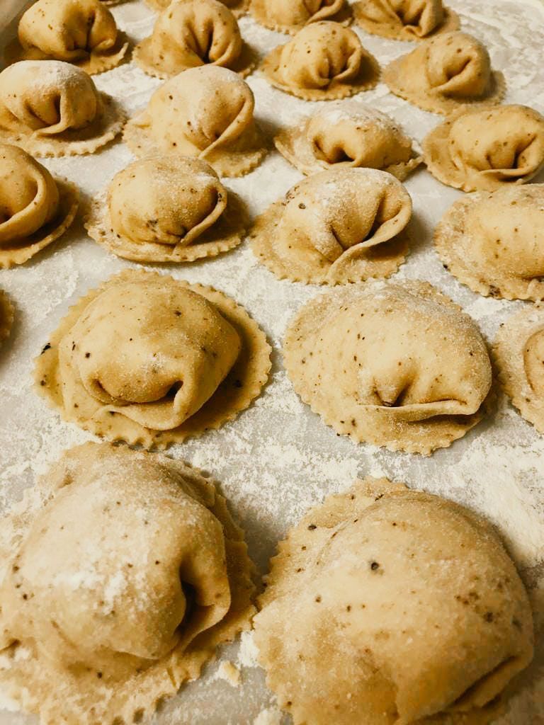Verse gevulde pasta op met bloem bestoven werkblad.