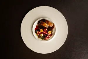 Verfijnd gerecht op een groot wit bord.