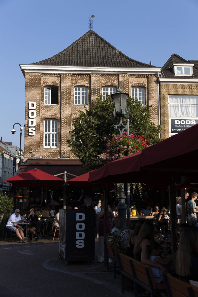 Gevel met zichtbare DODS-naam en terras.