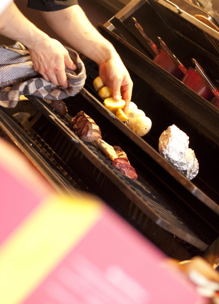 Bereiding van gerechten op de houtskoolgrill.