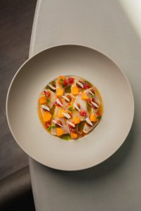 Kleurrijk gerecht op een groot rond bord.
