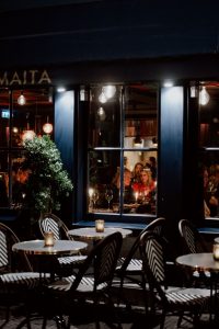 Avondbeeld van de gevel en het terras van Maita.