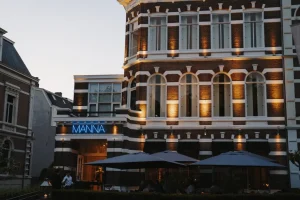 Avondgevel met herkenbare MANNA-naam en terras.