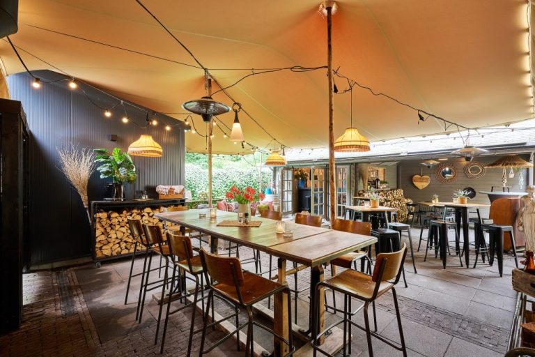 Zitruimte met lange houten tafel en losse stoelen.
