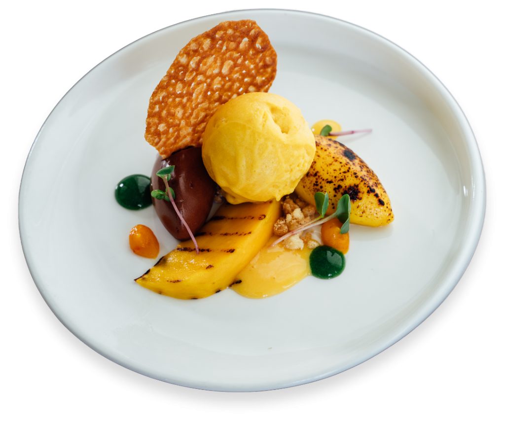Dessert met ijsbol en krokante decoratie op wit bord.
