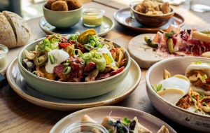 Gedekte tafel met diverse gerechten, salade en bijgerechten.