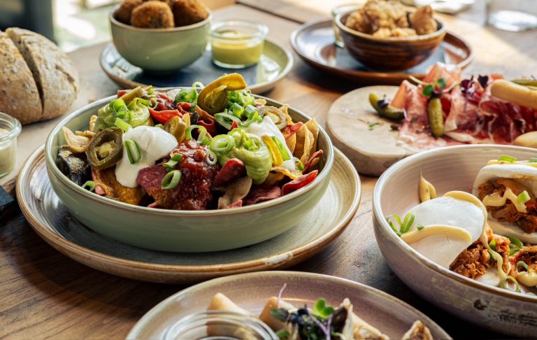 Gedekte tafel met diverse gerechten, salade en bijgerechten.