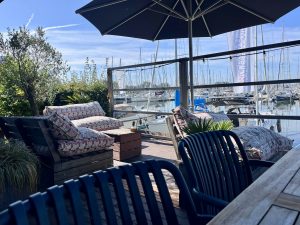 Loungeterras met parasol en zicht op de jachthaven.