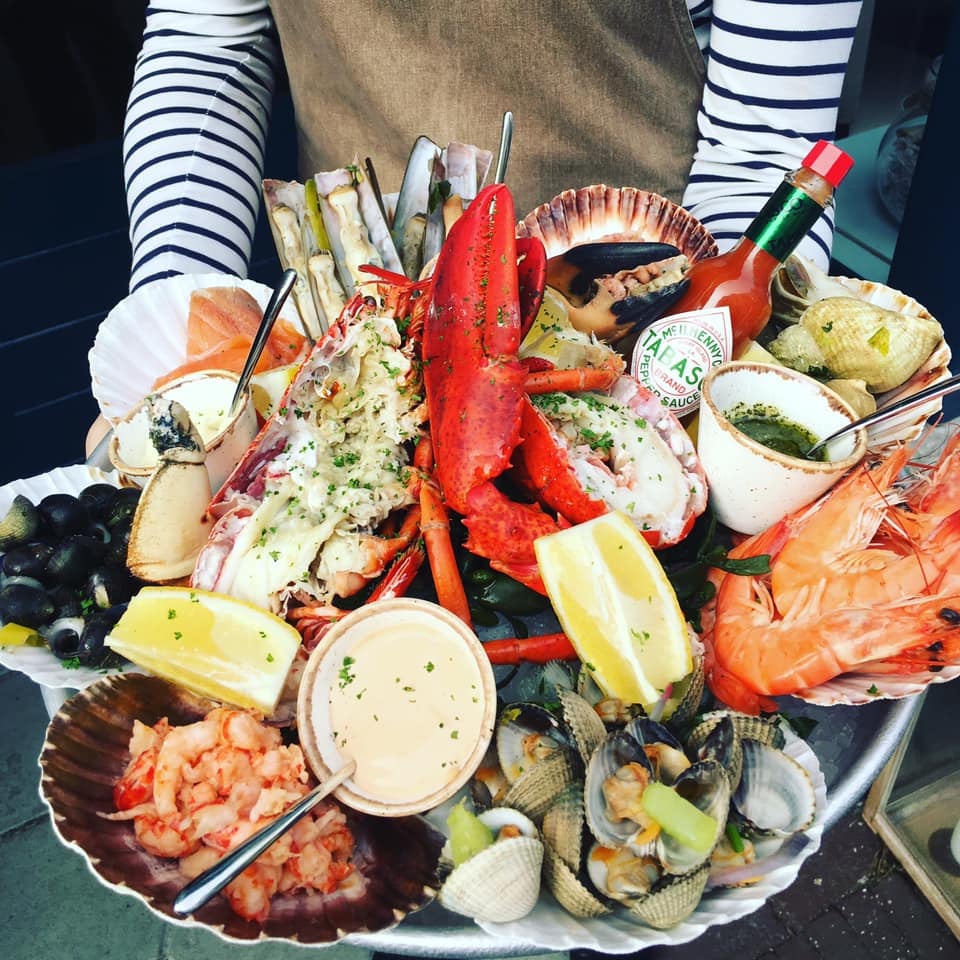Plateau fruits de mer met kreeft, schelpdieren en citroen.