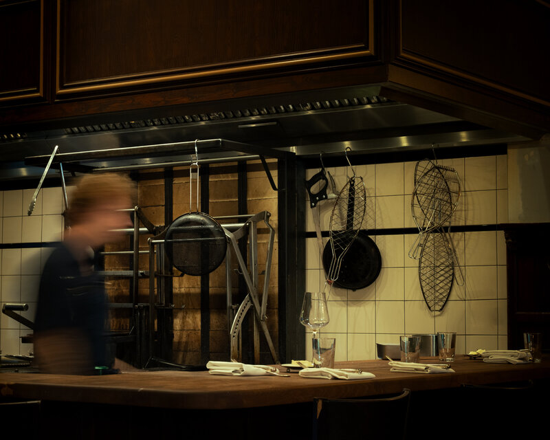 Restaurantcounter met gedekte plekken voor een open keuken.