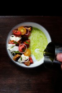Kleurrijk opgemaakt gerecht op een donker tafelblad.