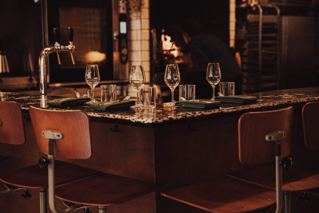 Gedekte zitplaatsen aan donkere natuurstenen bar.