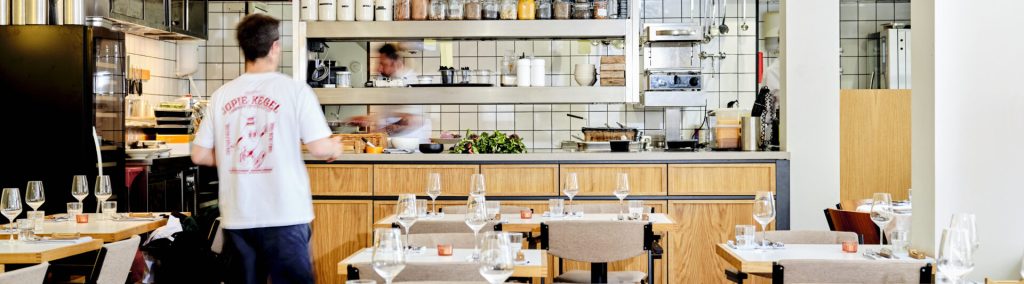 Restauranttafels en open keuken.