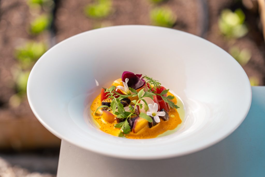 Gerecht met kruiden en bloemen in een diepe witte kom.