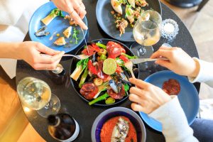 Bovenaanzicht van tapas, schaal- en schelpdieren en wijn op restauranttafel.