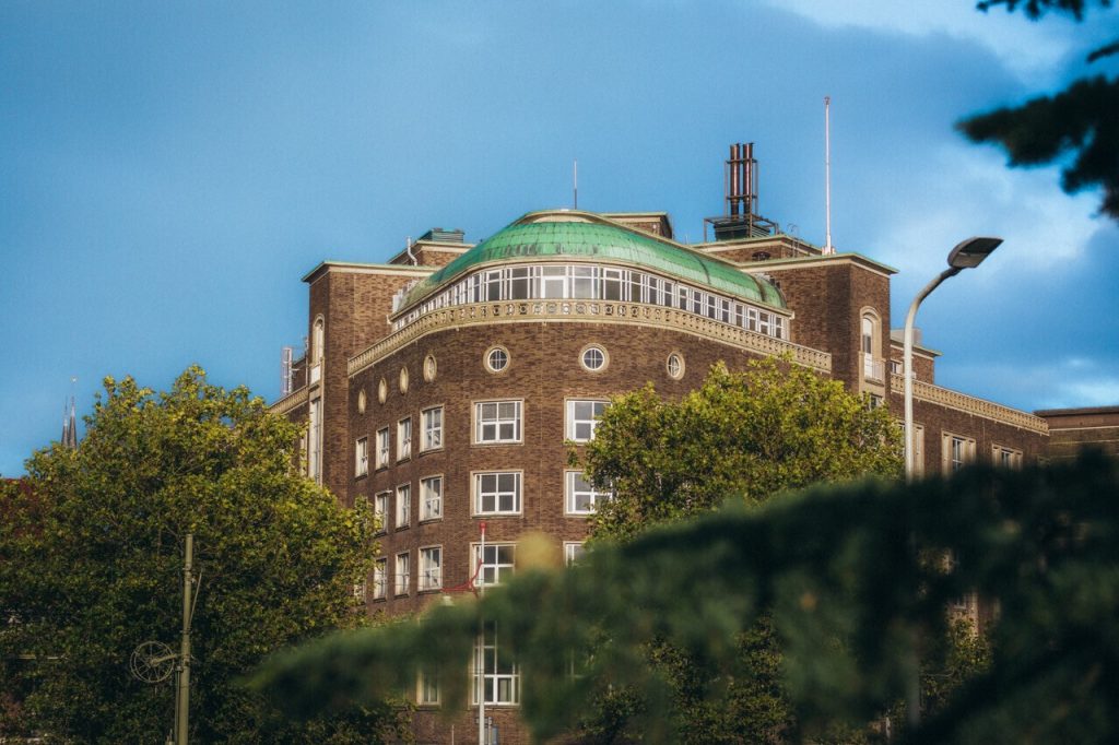 Exterieur van het ronde Flora-gebouw onder een blauwe lucht, afkomstig uit het restaurantblok op de eigen site.