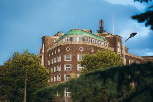Exterieur van het ronde Flora-gebouw onder een blauwe lucht, afkomstig uit het restaurantblok op de eigen site.