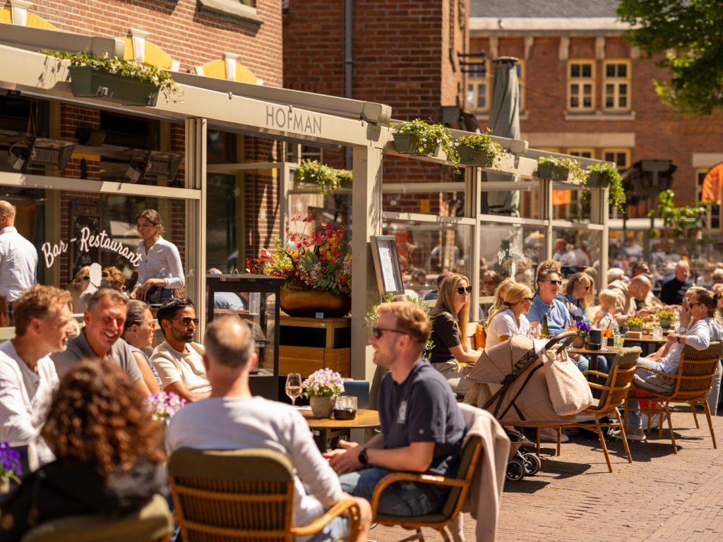 Drukbezocht buitenterras voor de herkenbare Hofman-gevel aan het Kerkplein.