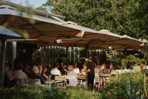 Gasten op het groene terras van restaurant De Kas.