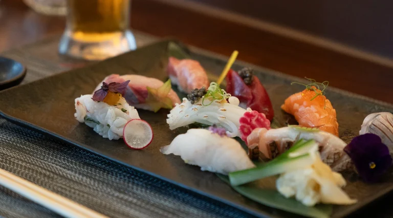 Sushi en sashimi op een langwerpig bord.